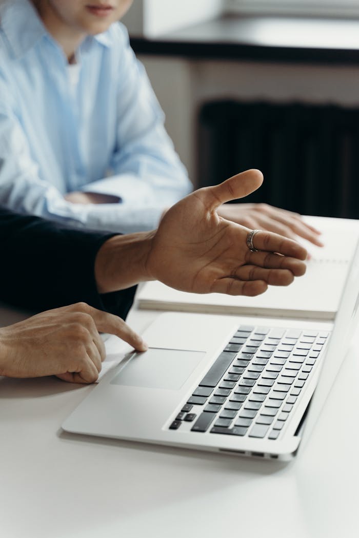 who-we-are Business professionals discussing work on a laptop in an office setting.